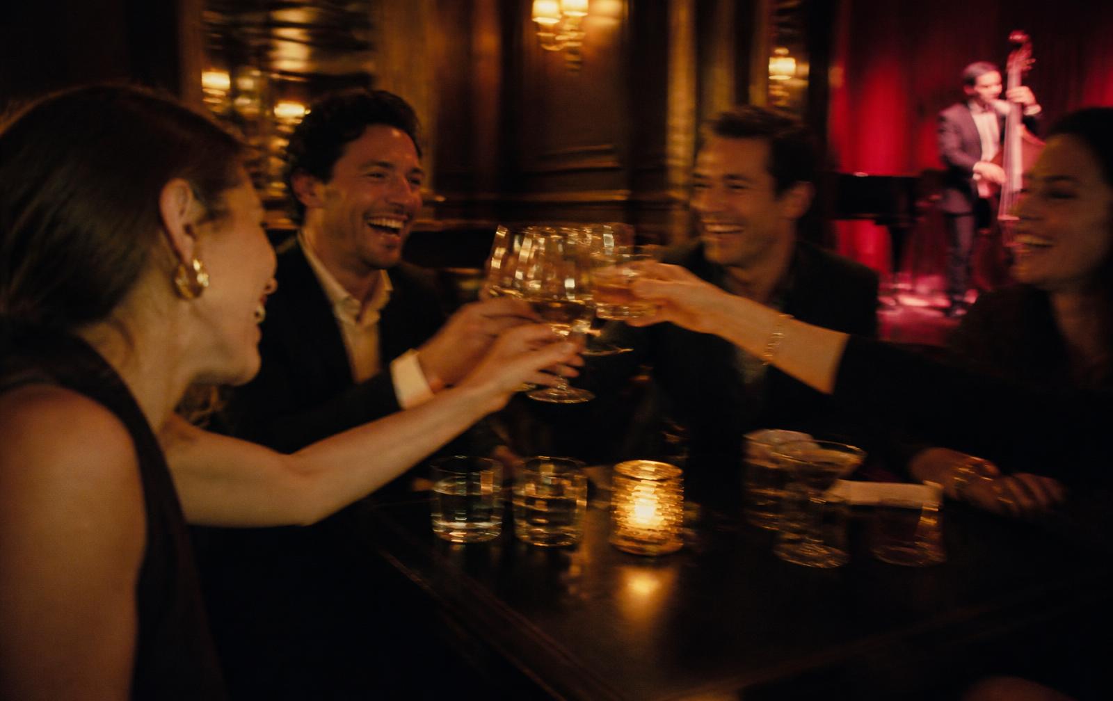 Amigos brindando em uma noite de bar com luz quente